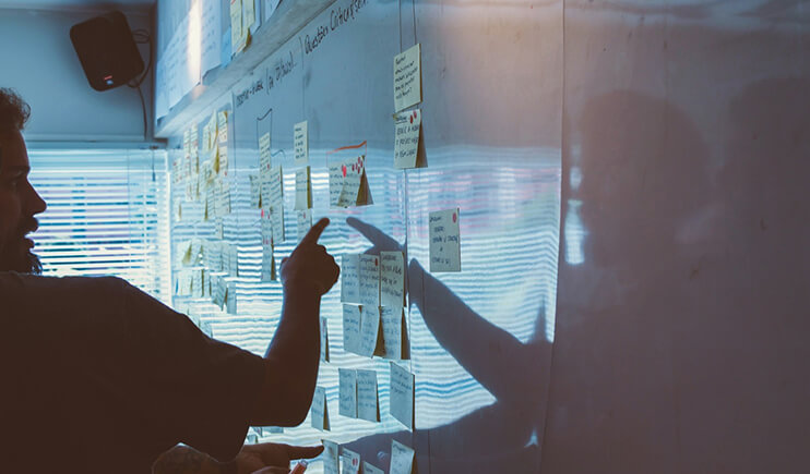 Persona revisando pizarra con postit